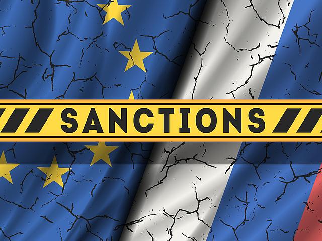 EU- und Russland-Flagge mit der Aufschrift "Sanctions"