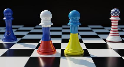 Schachbrett mit Figuren in EU-, Russland-, Ukraine und USA-Farben