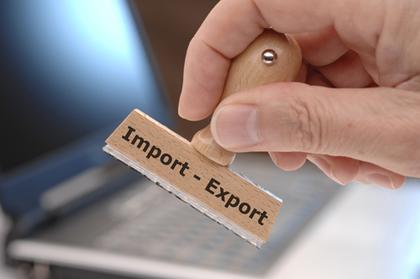 Hand hält Stempel "Import - Export"