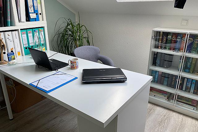 Büro mit Schreibtisch und Laptop