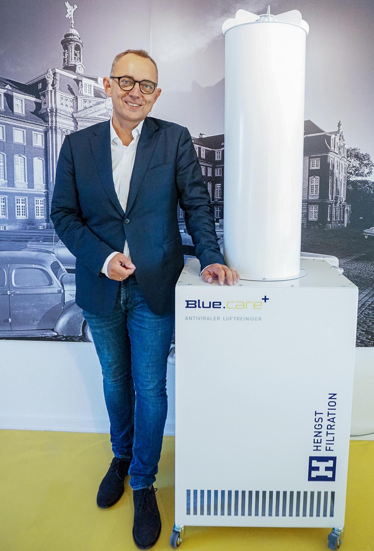 Mann steht neben Luftfilter-Anlage
