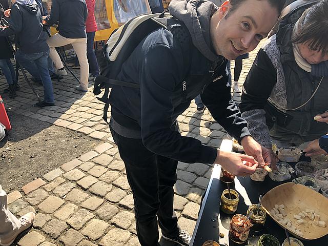 Ein Mann probiert Brot an einem Marktstand