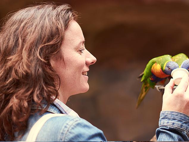 Frau füttert Papagei