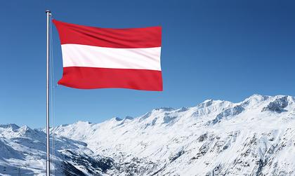 Österreich-Flagge vor verschneiten Bergen