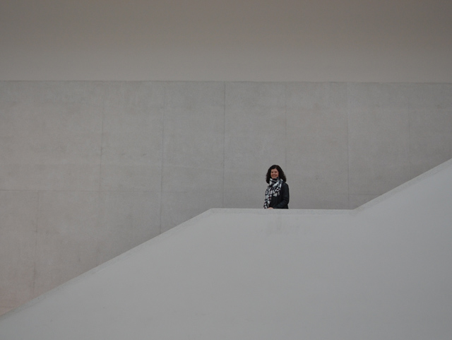 Frau steht auf Treppe im Museum.